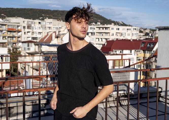 Образ худощавого мужчины в объёмной белой футболке с брюками для летнего стиля